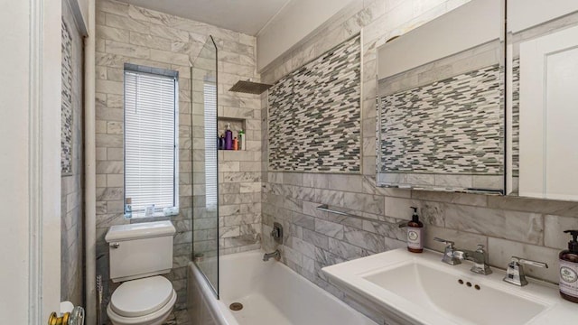 bathroom featuring washtub / shower combination, a sink, tile walls, toilet, and tasteful backsplash