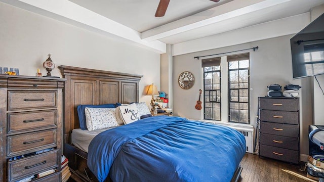 bedroom with dark wood finished floors, beamed ceiling, and a ceiling fan