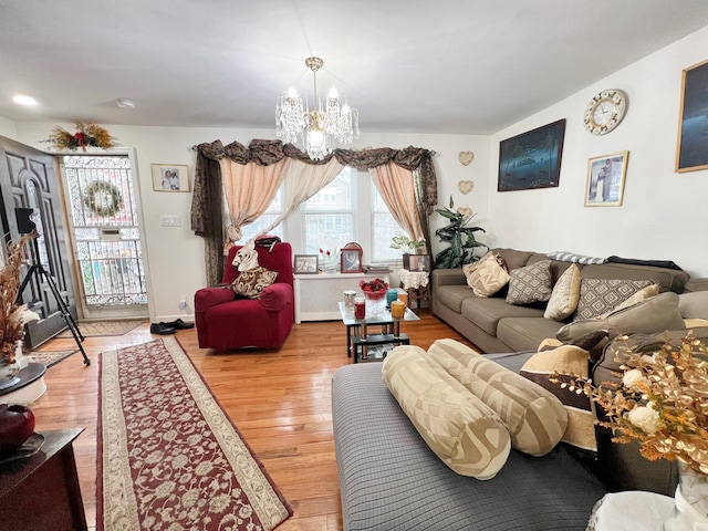 living area featuring light wood-style flooring, baseboards, and a chandelier