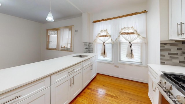 kitchen featuring white cabinetry, light countertops, tasteful backsplash, and light wood finished floors