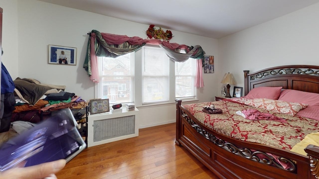 bedroom with light wood-type flooring and baseboards