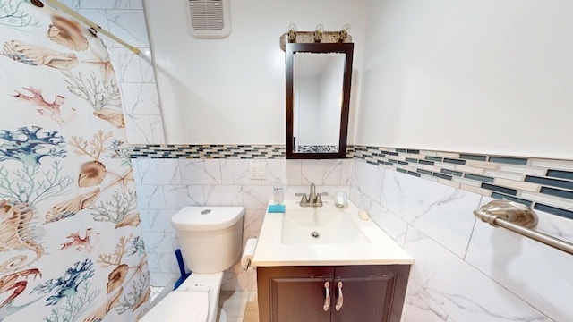 bathroom with visible vents, toilet, tile walls, and vanity