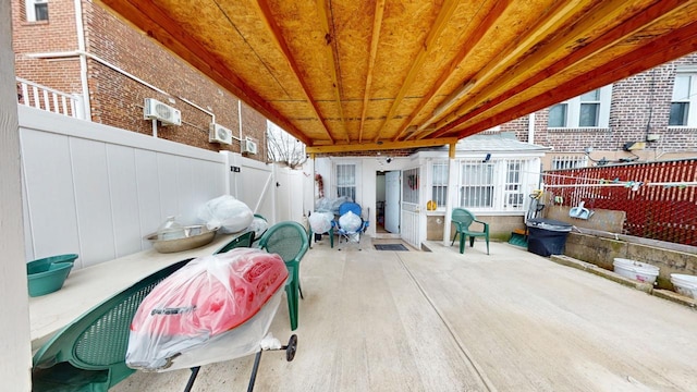 view of patio / terrace with a wall unit AC and a fenced backyard