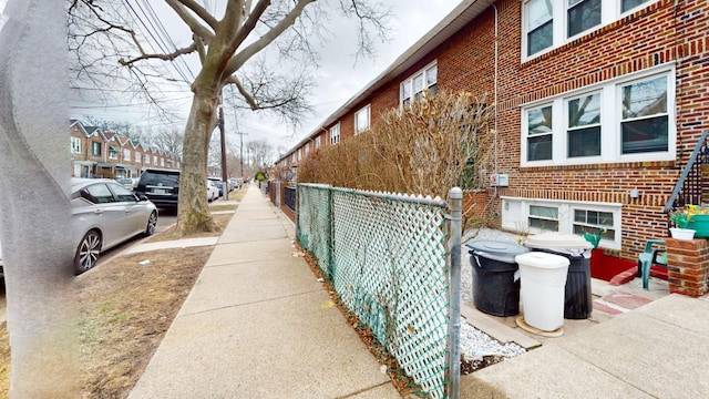 view of home's exterior featuring fence and brick siding