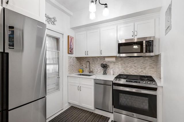 kitchen featuring a sink, tasteful backsplash, white cabinetry, and stainless steel appliances