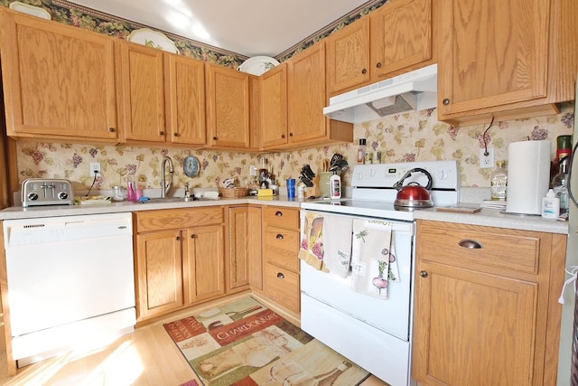 kitchen with wallpapered walls, white appliances, light countertops, and under cabinet range hood