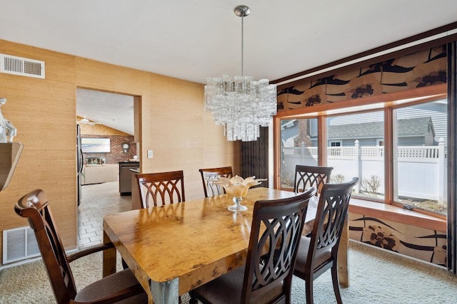 dining room with an inviting chandelier, visible vents, and vaulted ceiling