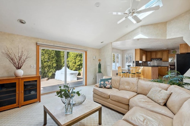 living area featuring lofted ceiling with skylight, recessed lighting, light carpet, and a ceiling fan