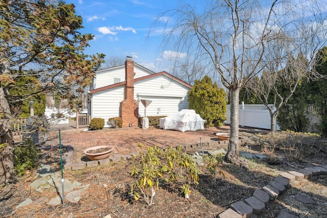 view of home's exterior with a chimney and fence