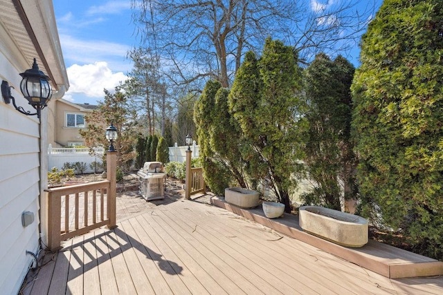 wooden deck with area for grilling and fence