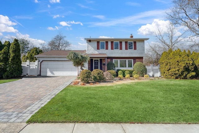 colonial inspired home featuring a gate, decorative driveway, fence, a front yard, and a garage