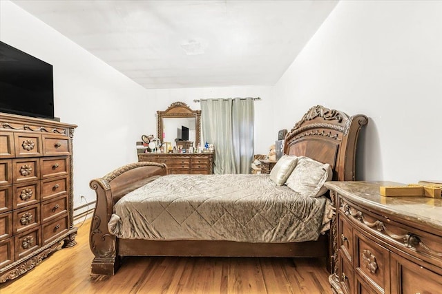 bedroom featuring baseboard heating and light wood-style floors