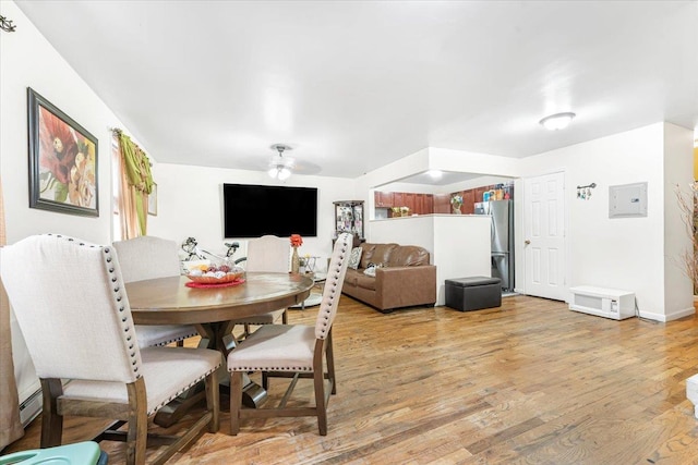 dining space featuring ceiling fan, baseboards, and light wood-style flooring