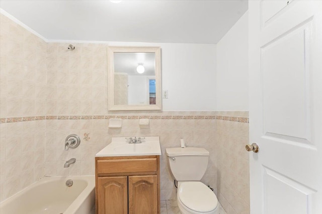 bathroom featuring vanity, bathing tub / shower combination, wainscoting, tile walls, and toilet