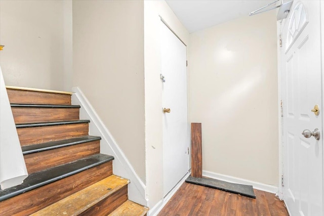 staircase with baseboards and wood finished floors