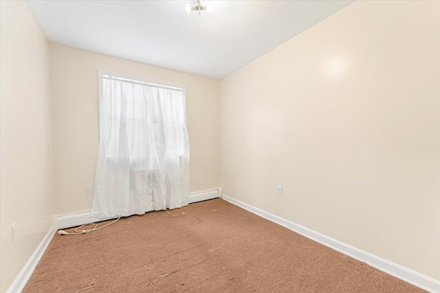 unfurnished room with baseboard heating, baseboards, and carpet