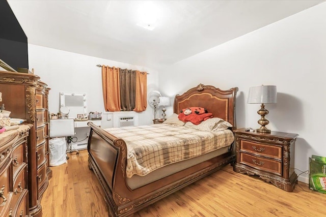 bedroom with light wood-type flooring and a wall mounted air conditioner