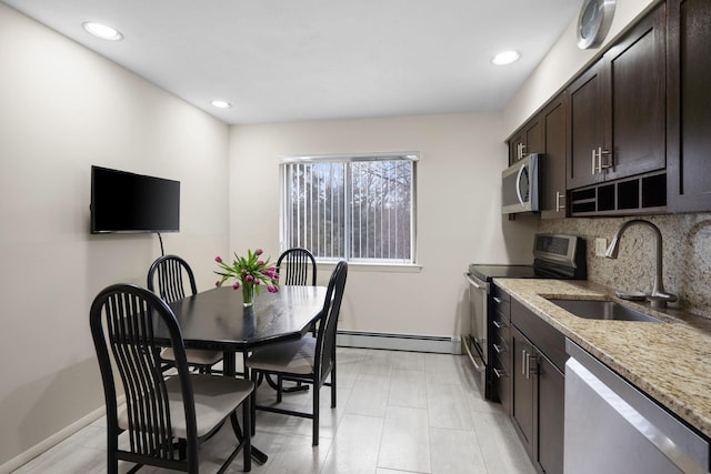 kitchen with a sink, tasteful backsplash, stainless steel appliances, dark brown cabinetry, and a baseboard radiator