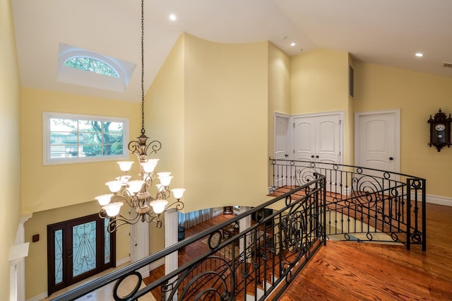 83 Ithaca Ave, Atlantic Beach, NY 11509 - hallway featuring high vaulted ceiling, a chandelier, an upstairs landing, a wealth of natural light, and wood finished floors