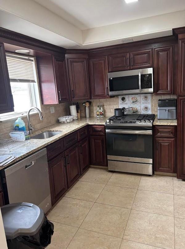 162-30 89th St, Howard Beach, NY 11414 - kitchen with decorative backsplash, light tile patterned flooring, stainless steel appliances, a sink, and light stone counters