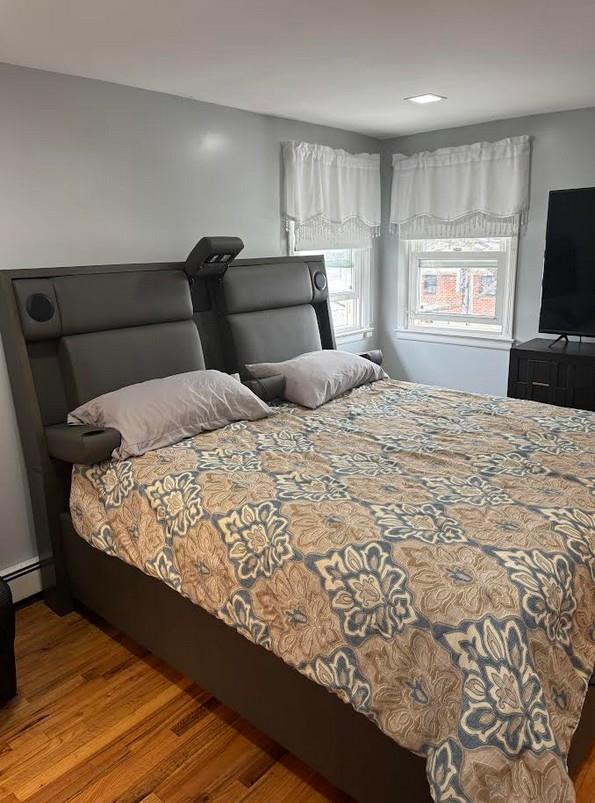 162-30 89th St, Howard Beach, NY 11414 - bedroom featuring a baseboard radiator and wood finished floors