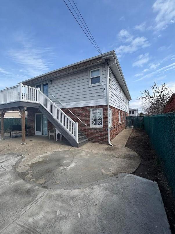 162-30 89th St, Howard Beach, NY 11414 - back of property with a patio, brick siding, a fenced backyard, and stairway