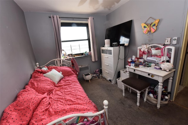 carpeted bedroom with radiator and ceiling fan