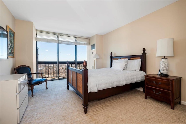 bedroom with access to exterior, expansive windows, and light colored carpet