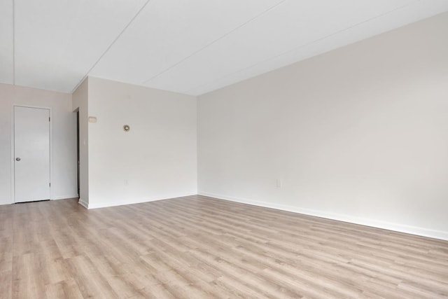 spare room with light wood-style floors and baseboards