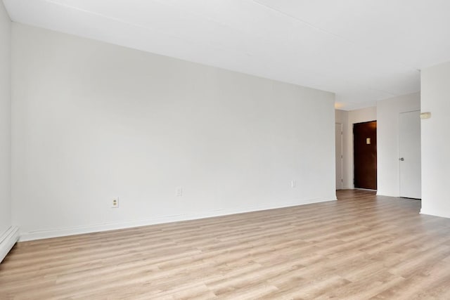 unfurnished room with light wood-type flooring and baseboards