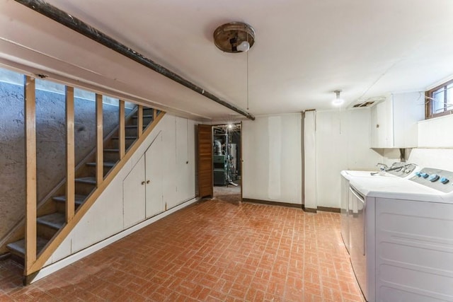 basement featuring washer and dryer, stairway, and brick floor