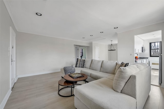 living area with recessed lighting, light wood-type flooring, baseboards, and crown molding