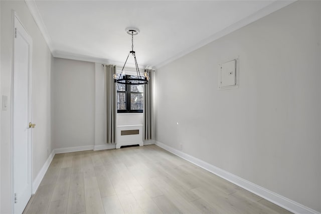 unfurnished dining area with an inviting chandelier, crown molding, light wood-style floors, and baseboards