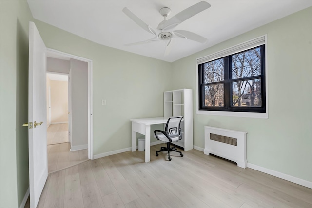 office space with ceiling fan, radiator heating unit, baseboards, and wood finished floors