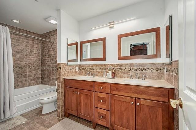 bathroom featuring shower / bathtub combination with curtain, toilet, a sink, tile walls, and double vanity