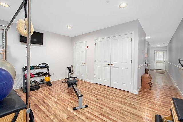 exercise area featuring recessed lighting, baseboards, and light wood-style flooring