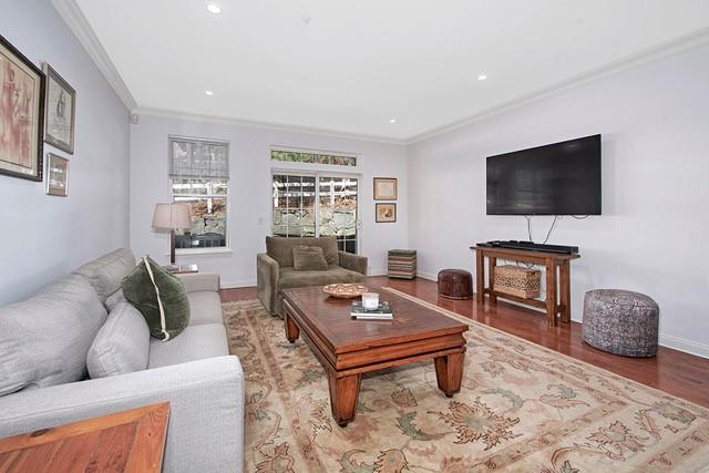 living area featuring recessed lighting, wood finished floors, baseboards, and ornamental molding