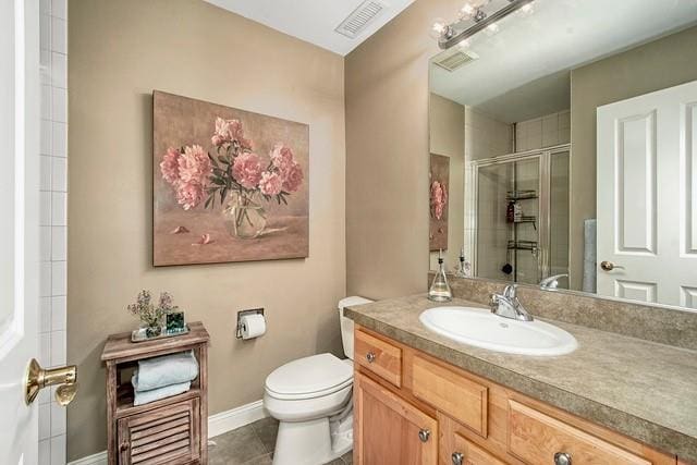 bathroom featuring a shower with door, visible vents, toilet, tile patterned floors, and vanity