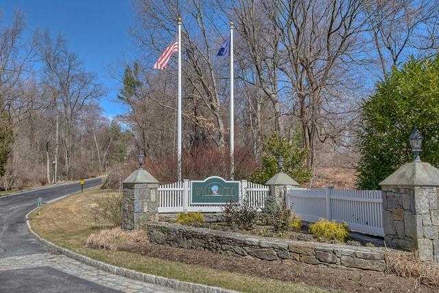 community / neighborhood sign with a gate and fence