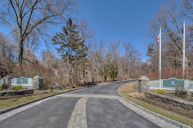 view of road featuring curbs and a gate