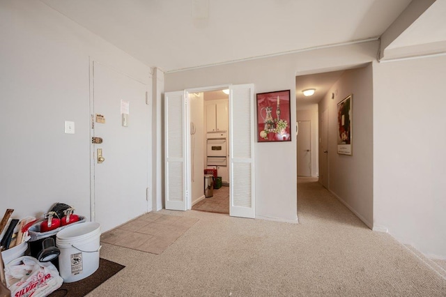 interior space with baseboards and light carpet