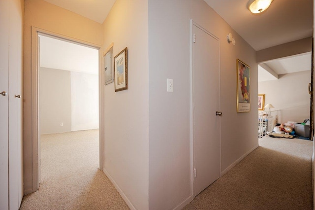 hallway with light colored carpet and baseboards