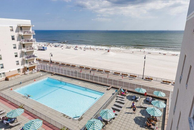 view of swimming pool featuring a beach view and a water view