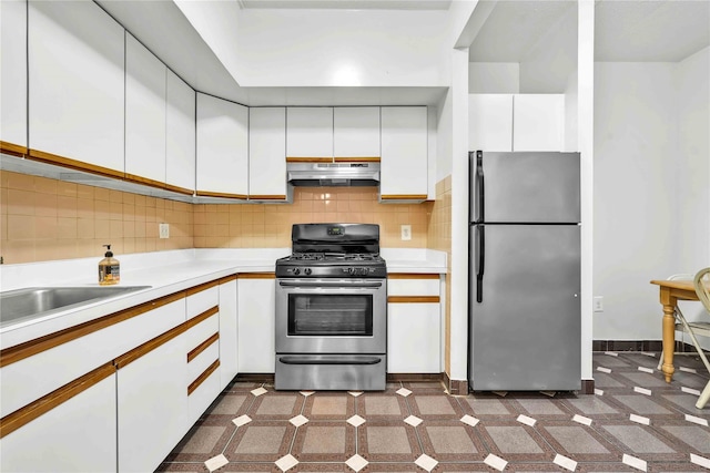 kitchen featuring under cabinet range hood, white cabinetry, stainless steel appliances, and light countertops