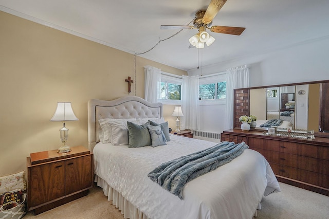 bedroom with ornamental molding, radiator heating unit, a ceiling fan, and light carpet