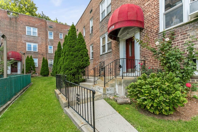 view of community featuring a yard and fence