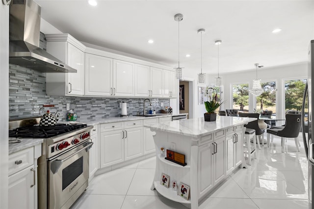 kitchen with a sink, stainless steel appliances, white cabinets, wall chimney range hood, and light tile patterned floors