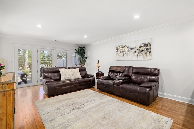 living room with crown molding, baseboards, and wood finished floors