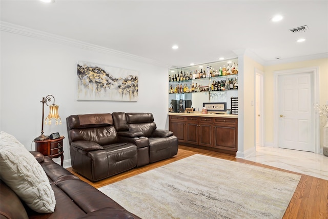 living area featuring visible vents, recessed lighting, light wood-style floors, crown molding, and a dry bar