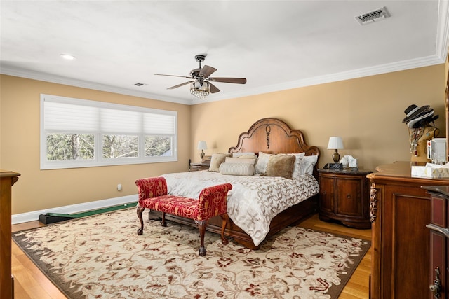 bedroom with visible vents, light wood-style floors, and ornamental molding